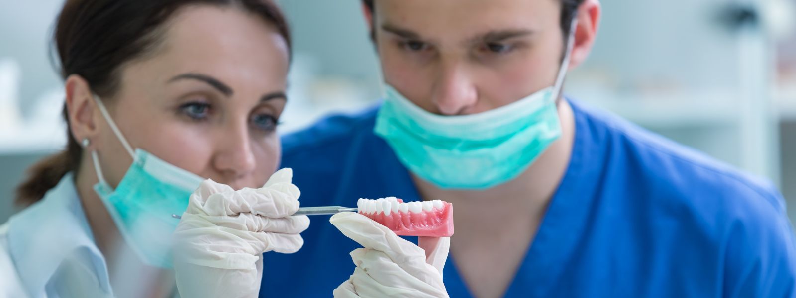 two dentists examine an implant